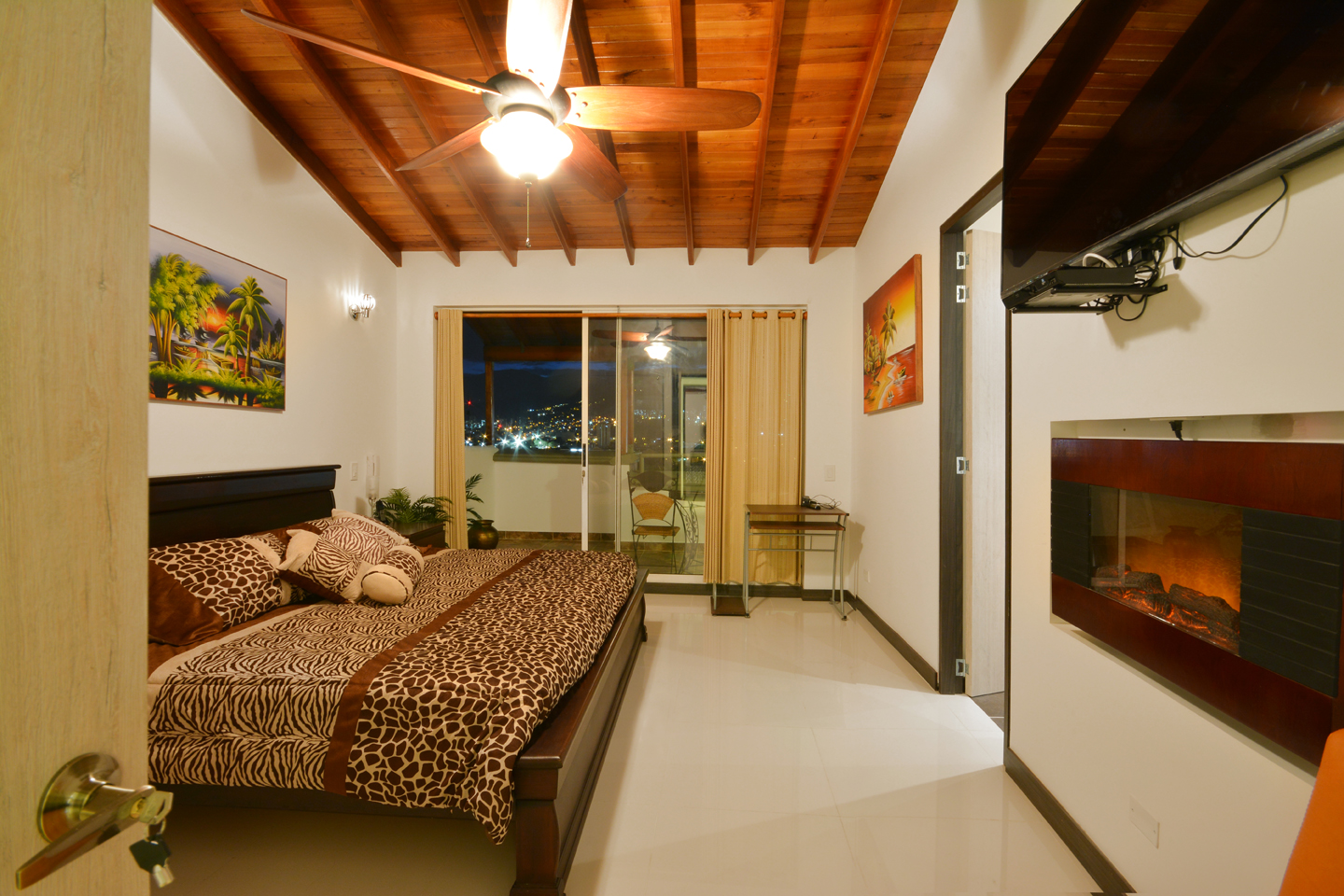 Bedroom 1 with fireplace, outdoor deck, flat screen TV, high ceilings and ceiling fan in Astorga duplex
