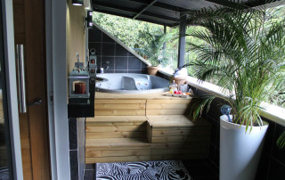 A wooden deck with a tub and zebra rug.