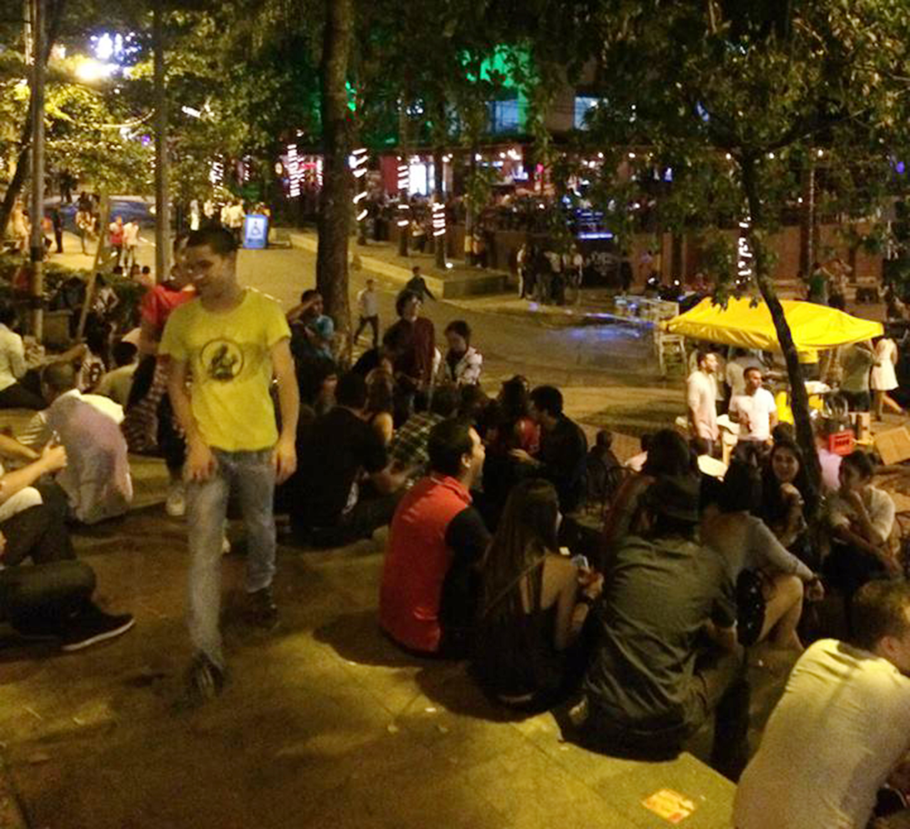 A group of people sitting on the ground at night.