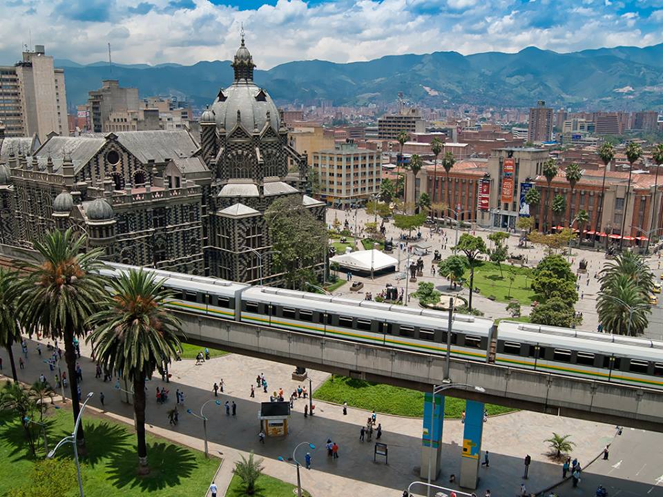 A train is traveling down the tracks in a city.