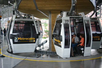 Two people are sitting on a cable car.