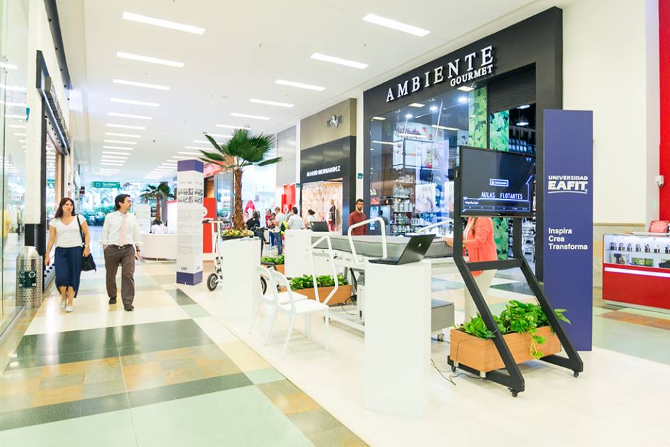 A man walking in an indoor mall with many displays.