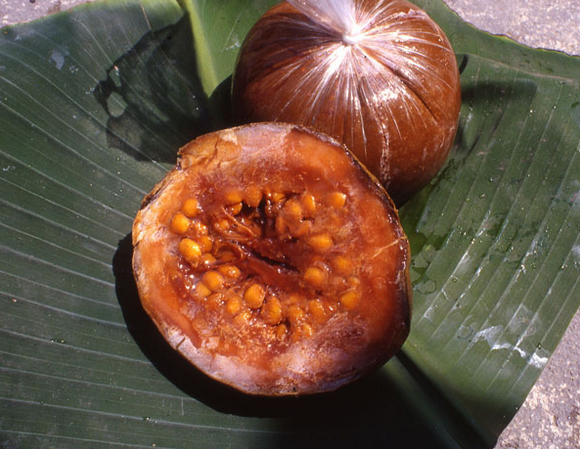 A close up of an open fruit on top of a leaf.