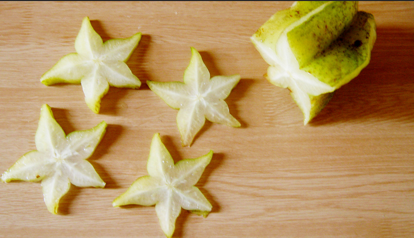 A wooden table topped with cut up fruit.