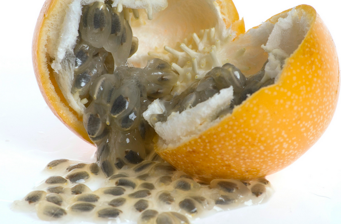 A close up of an orange with some black spots