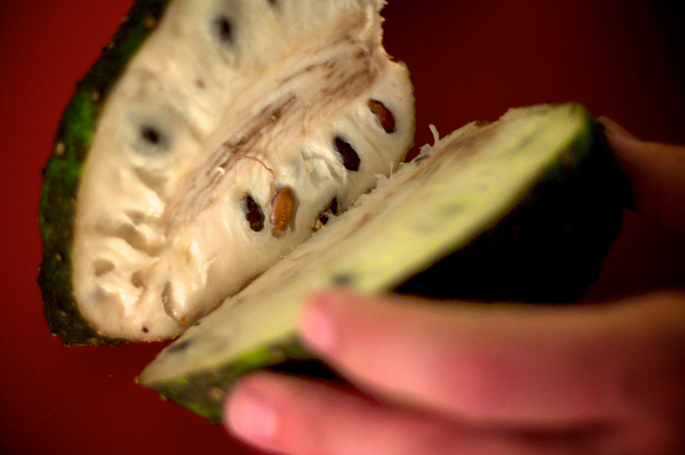 A person holding an open pineapple in their hand.