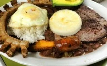 A plate of food with meat, rice and an avocado.