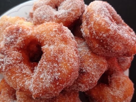 A close up of some powdered donuts on a plate