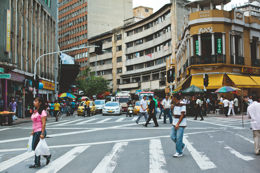 A busy street with many people crossing the road.