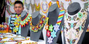 A display of colorful necklaces and bracelets on stands.