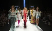 A group of women walking down the runway.